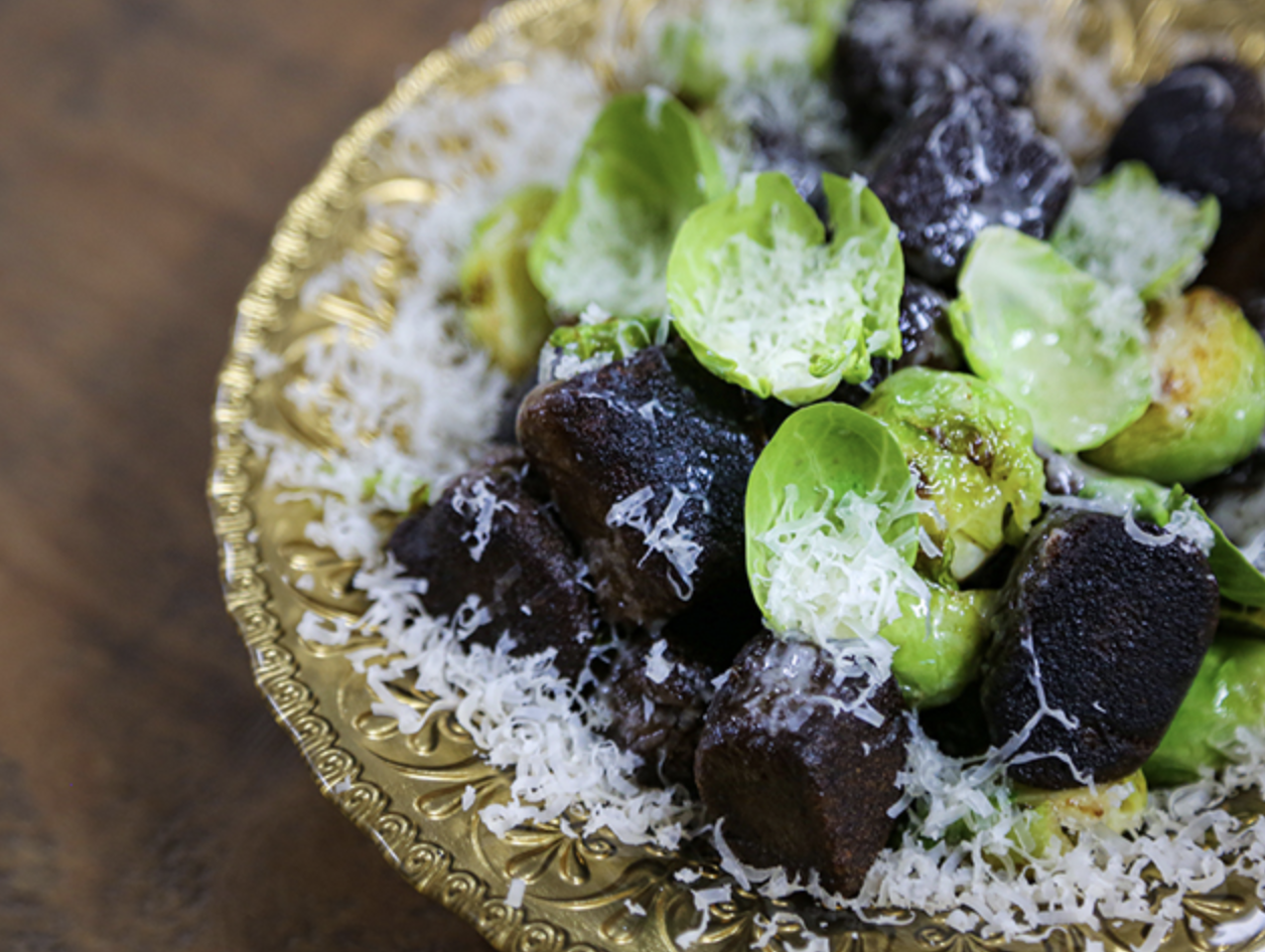 Black Garlic Gnocchi With Roasted Sprouts dish served